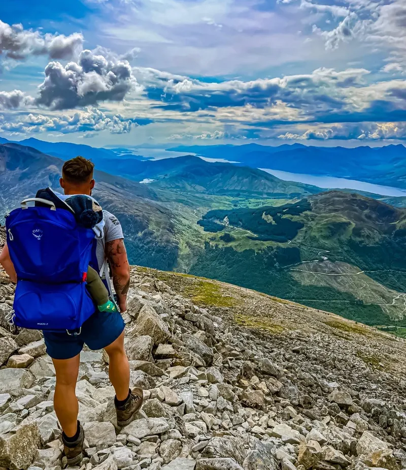 Alex with a loaded pack on a mountain ridge