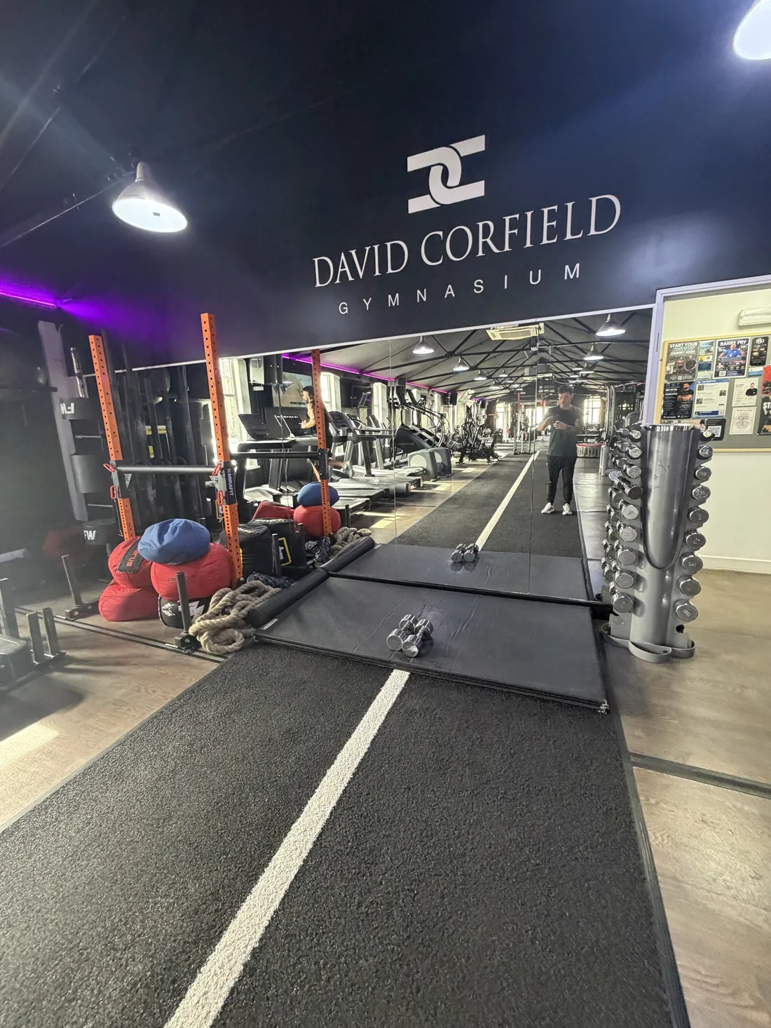 The main floor at David Corfield Gymnasium with the gym's sign on the back wall