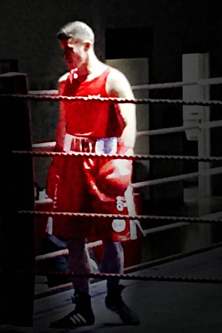 A boxer in Army red waiting in his corner before a bout